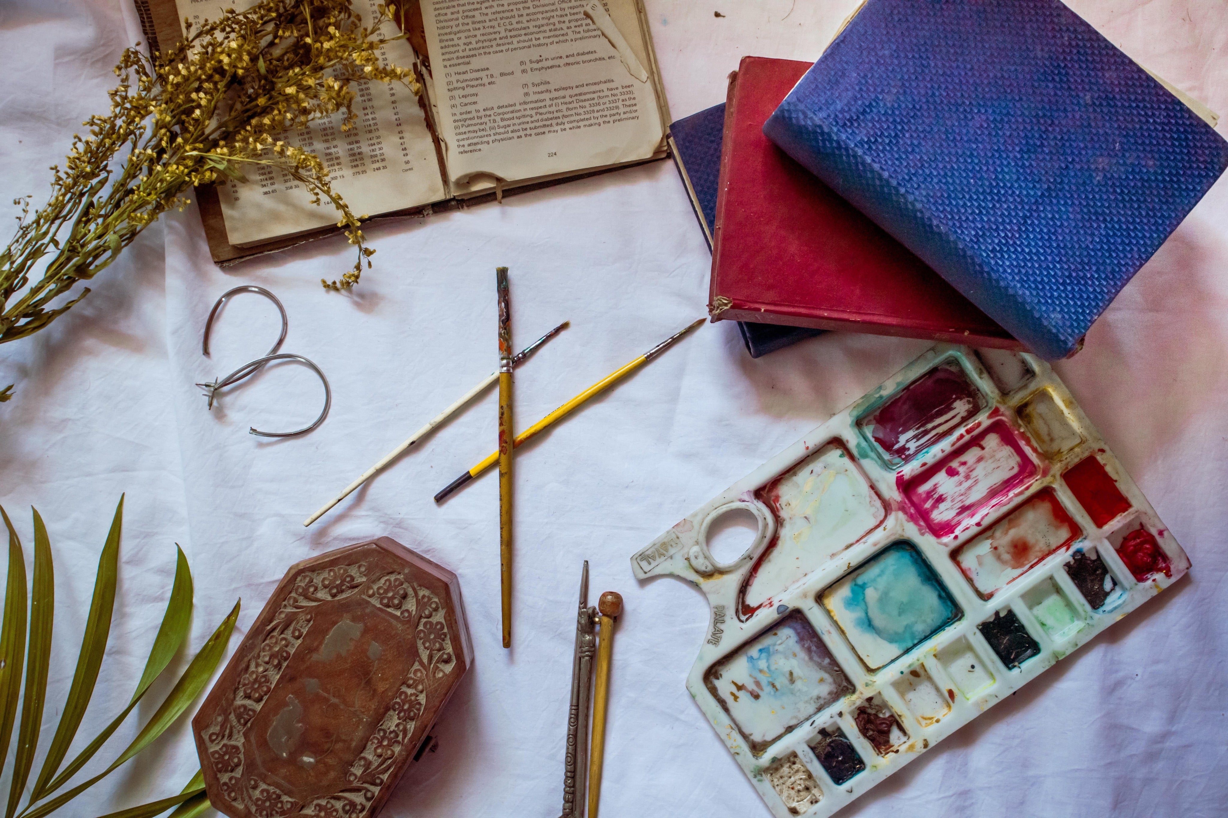 flatlay-of-painting-supplies-and-books-with-dried-flowers.jpg